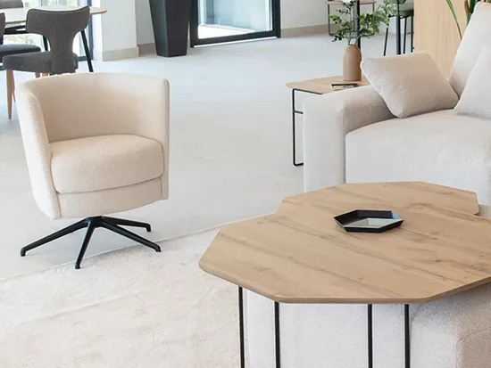Fauteuil pivotant Fama Peque en tissu clair, avec table basse dans un salon – Meubles Bouchiquet à Bergues (59)