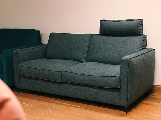 Canapé convertible gris foncé White vu de trois quarts dans un salon lumineux