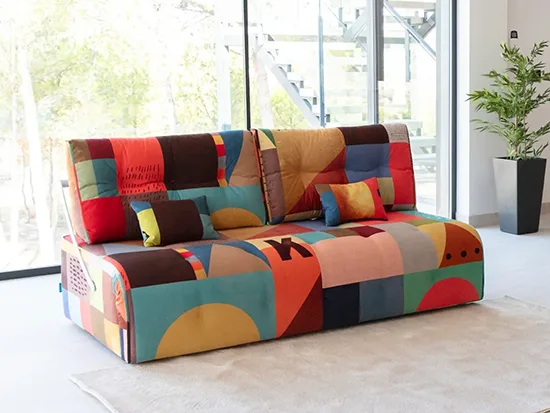 Canapé relax convertible Fama Indy en tissu multicolore, présenté dans un salon lumineux – Meubles Bouchiquet à Bergues (59)