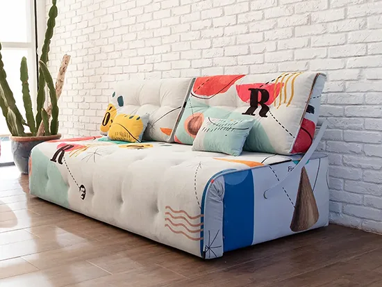 Canapé relax convertible Fama Indy multicolore, présenté avec un fauteuil rouge – Meubles Bouchiquet à Bergues (59)