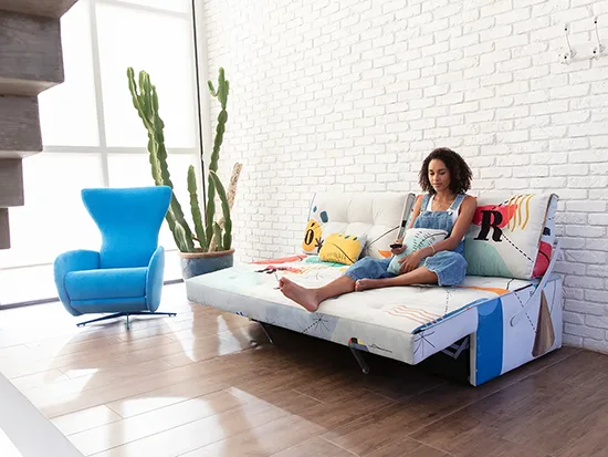 Canapé relax convertible Fama Indy avec une personne, vue de trois quarts droite – Meubles Bouchiquet à Bergues (59)