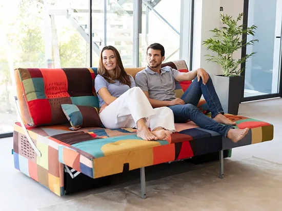 Canapé relax convertible Fama Indy avec deux personnes assises, vue de face – Meubles Bouchiquet à Bergues (59)