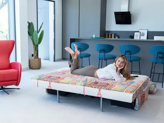 Canapé relax convertible Fama Indy avec une personne allongée, vue de trois quarts – Meubles Bouchiquet à Bergues (59)