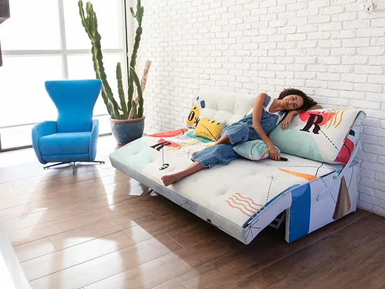 Canapé relax convertible Fama Indy avec une personne assise, présenté de face – Meubles Bouchiquet à Bergues (59)