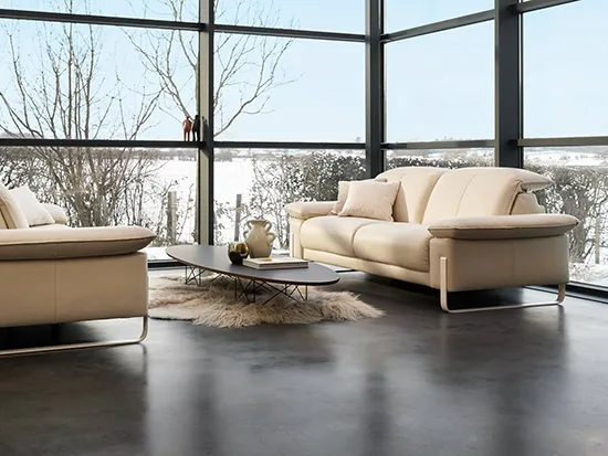 Canapé relax électrique rom1961 Sereno beige installé devant une grande baie vitrée