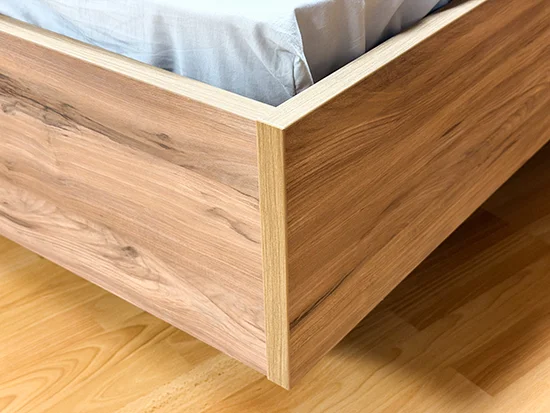 Détail du cadre de lit en bois et métal noir de la chambre Thalya