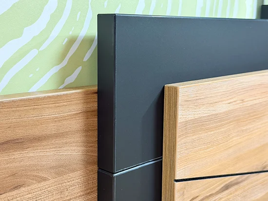 Détail de la tête de lit en bois avec motif décoratif noir de la chambre Thalya