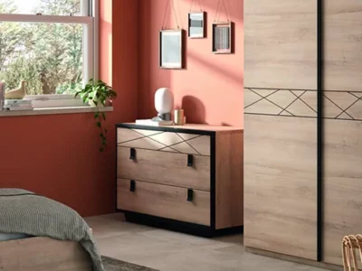 Commode en bois et métal noir devant une armoire assortie dans une chambre terracotta