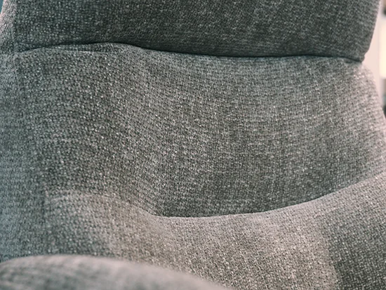 Détail du coussin lombaire du fauteuil relax gris en tissu